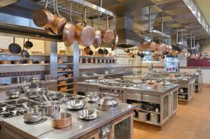 Large commercial kitchen featuring multiple gas ovens and stoves